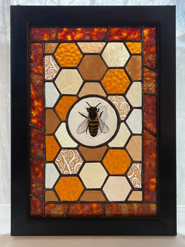 Image of a bee in a honeycombed shaped background rendered in stained glass
